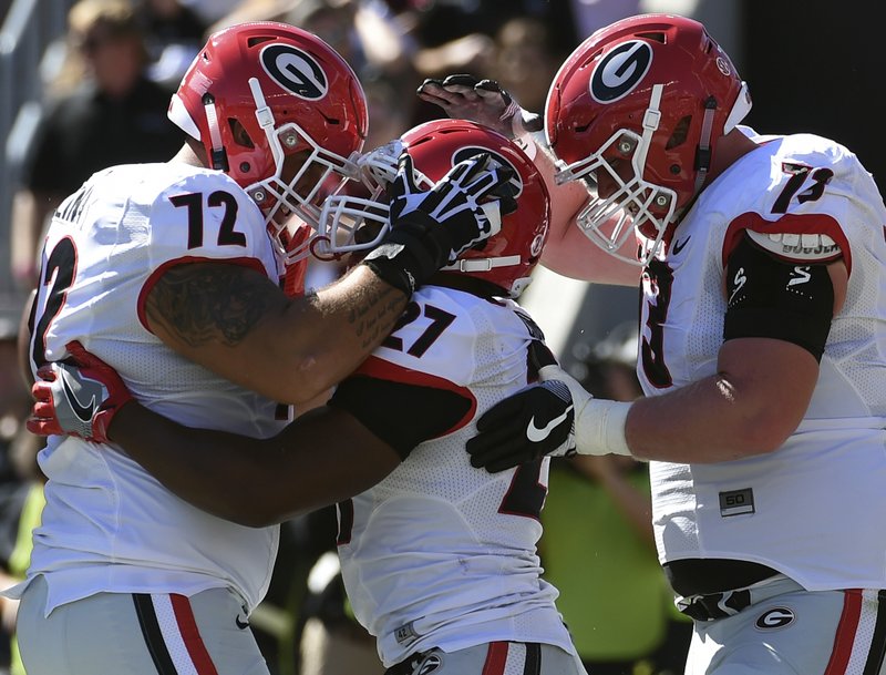 Georgia running back Nick Chubb (27) celebrates a touchdown with teammates Tyler Catalina (72) and Greg Pyke (73) during the first half of an NCAA college football game against South Carolina on Sunday, Oct. 9, 2016, in Columbia, S.C. 