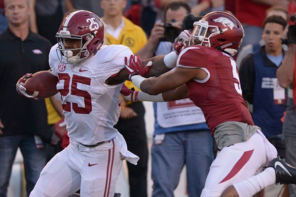 Alabama running back Joshua Jacobs (25) stiff arms Arkansas defensive back Henre' Toliver during a game Oct. 8, 2016, in Fayetteville. 