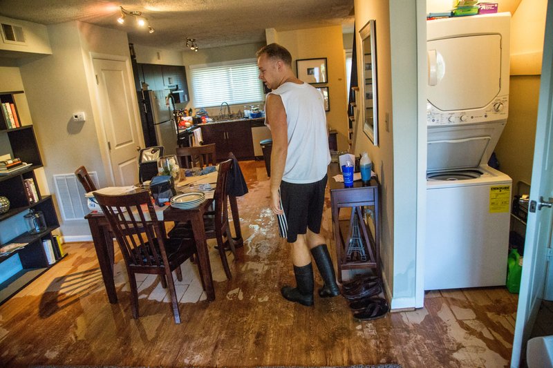Jeremy Spearman checks on flood damage to his Parkside Five Points Townhomes apartment in Raleigh, N.C., after Hurricane Matthew caused downed trees and flooding Sunday, Oct. 9, 2016. Hurricane Matthew's torrential rains triggered severe flooding in North Carolina on Sunday as the deteriorating storm made its exit to the sea, and thousands of people had to be rescued from their homes and cars. (Travis Long/The News & Observer via AP)
