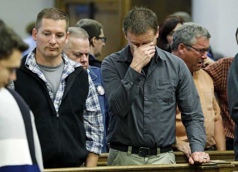 Family members of victims of the Oso landslide, including brothers Jason (left) and Dayn Brunner (center), react in King County Superior Court on Monday in Seattle after a settlement was reached in a lawsuit against the state of Washington and a timber company over a deadly landslide.