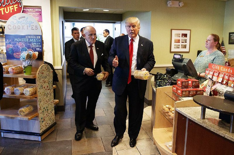 Former New York mayor Rudy Giuliani (left), accompanies Republican presidential candidate Donald Trump as he buys cookies during a visit to Eat’n Park restaurant Monday in Moon Township, Pa.