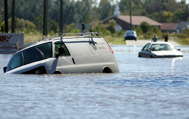 Abandoned vehicles sit in floodwaters at an intersection Monday in Goldsboro, N.C. Floodwaters are expected to continue to rise through today.