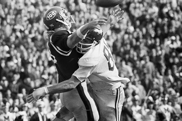 Arkansas left end Bruce James, right, forces Archie Manning of Ole Miss to get off a bad pass after a chase through the Rebels' backfield in Sugar Bowl game in New Orleans, Thursday, Jan. 1, 1970. The short pass was intercepted by Arkansas. Ole Miss led through most of the game. (AP Photo)