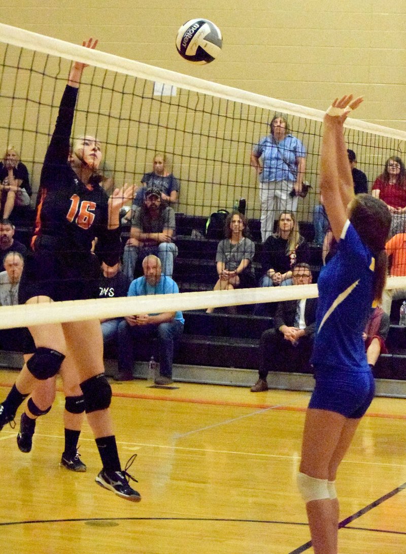 Photo by Mike Eckels Allie Callahan (Gravette 16) sends the ball over the net as Talor Thompson attempts to intercept the ball and tip it back into Lions&#8217; territory during the Decatur-Gravette senior girls&#8217; volleyball match in the old gym at Gravette High School Oct. 4. The Lions took the conference match in three straight sets.