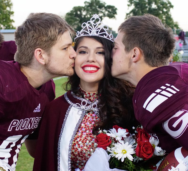 Photo by Randy Moll Jake Ernest and Cole Cripps, football captains at Gentry&#x2019;s homecoming ceremonies, give Lali Estrada a kiss on the cheek after she was crowned homecoming queen at Gentry High School on Friday, Oct. 7, 2016.