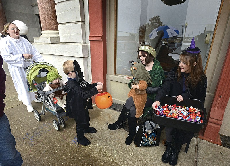 File Photo/BEN GOFF @NWABENGOFF Annette Shiley, from left, of Bentonville and her children Isaac and Hyrum get candy from Amanda Smith and son Ollie and Chelsea Gates during the 2015 Rogers Goblin Parade.