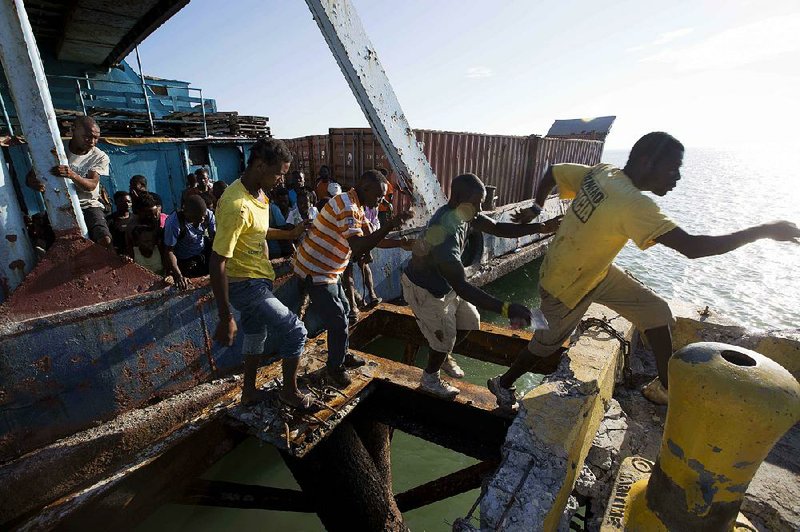 People try to get off a boat carrying aid as national police arrive to secure the boat as it docks in Jeremie, Haiti, on Wednesday in the aftermath of Hurricane Matthew. 
