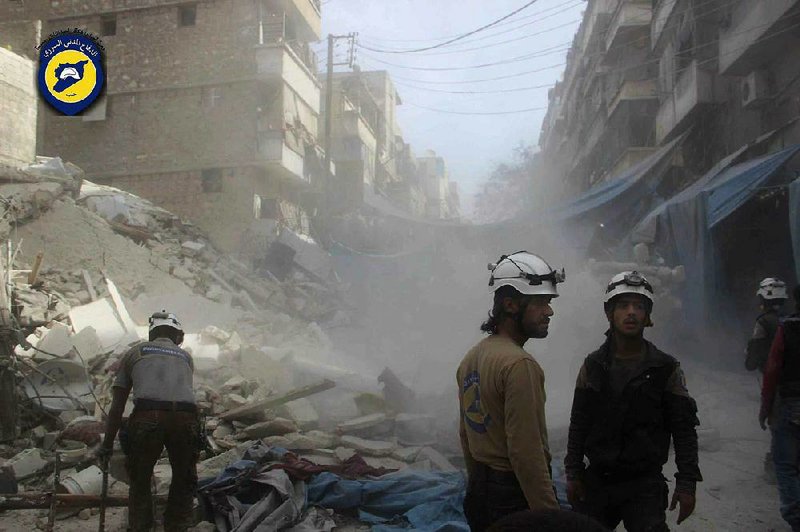 Syrian volunteer emergency workers search the rubble Wednesday in the besieged city of Aleppo, where the second airstrike in two days left at least 15 people dead at a large market.