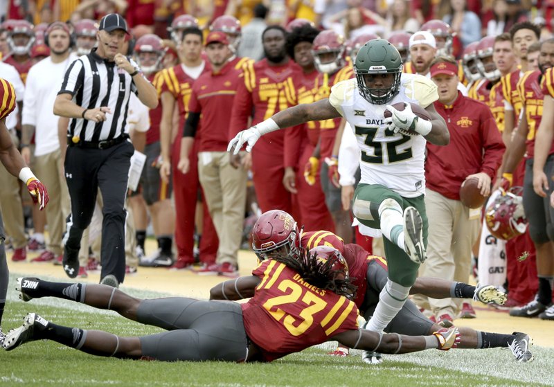 In this Oct. 1, 2016, file photo, Baylor running back Shock Linwood high steps through Iowa State defensive back Thadd Daniels and Iowa State defensive back Jomal Wiltz during the first half of an NCAA college football game, in Ames, Iowa.