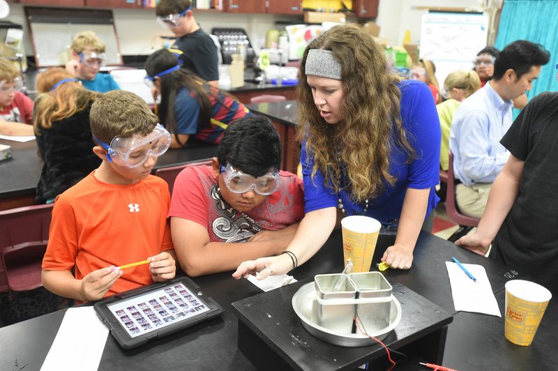 Tyler Van Vacter, (left) and Bryan Cenobite, sixth-graders, talk Wednesday with their teacher Cassie Kautzer as they experiment with thermoelectric generators during their science class at Hellstern Middle School in Springdale.