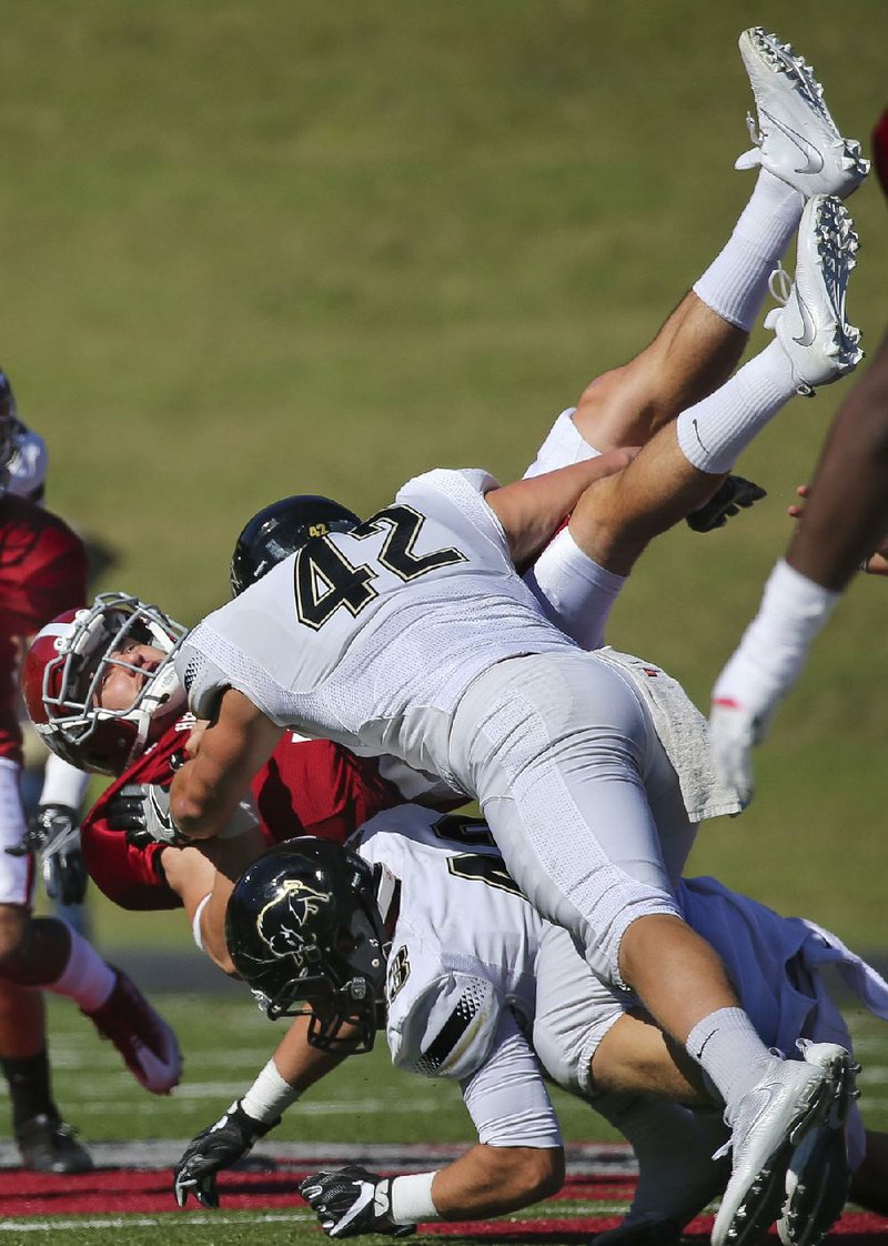 Harding defenders Sam Blankenship (42) and Benjamin Shields take down Henderson State quarterback Andrew Black during last week’s game. The Bisons, ranked No. 8 in the American Football Coaches Association NCAA Division II Top 25, are the only unbeaten team in the Great American Conference. 