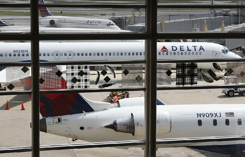 Delta Air Lines jets are parked at Ronald Reagan Washington National Airport in this August fi le photo. Delta, the first major U.S. airline to report third-quarter earnings, said Thursday that revenue fell 6 percent to $10.48 billion. 