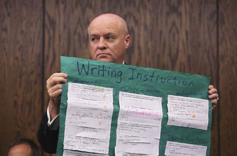 Little Rock School District Superintendent Mike Poore holds a visual aid Thursday as one of the district’s principals speaks during a report to the state Board of Education.