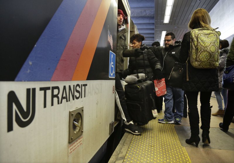 In this March 4, 2016 file photo, New Jersey Transit passengers board a train at Seacaucus Junction in Seacaucus, N.J. 
