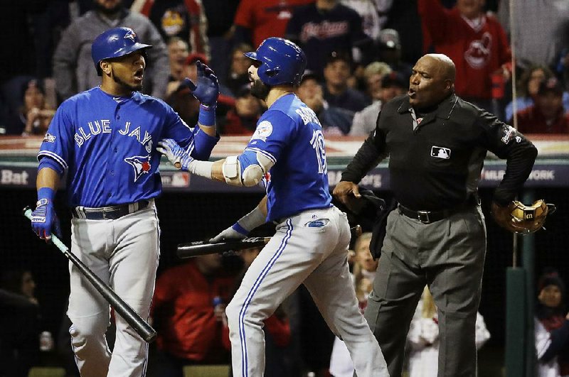 Toronto outfielder Jose Bautista (middle) pushes first baseman Edwin Encarnacion away from home plate umpire Laz Diaz (right) after Encarnacion was called out on strikes during the eighth inning of Friday’s 2-0 loss to the Cleveland Indians in Game 1 of the American League Championship Series in Cleveland.