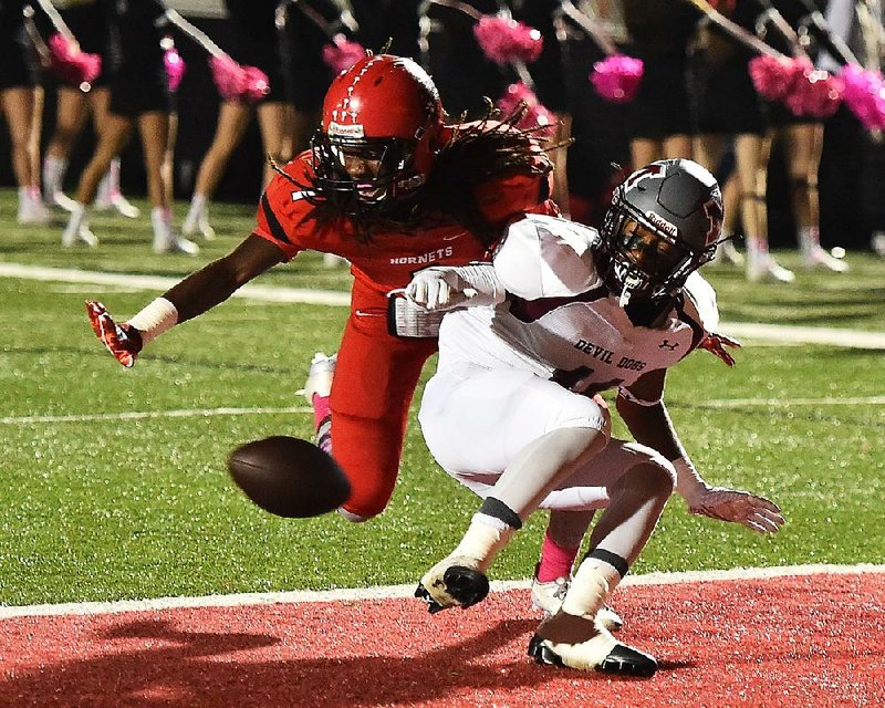 Maumelle defensive back Tyric Robinson (left) deflects a pass intended for Morrilton wide receiver Deiontae Duncan Friday. The Devil Dogs never trailed in beating the Hornets 53-21.