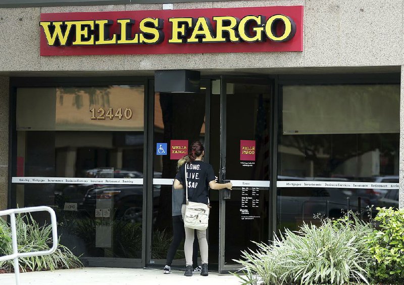 Customers walk into a Wells Fargo bank in Pembroke Pines, Fla. last month. 