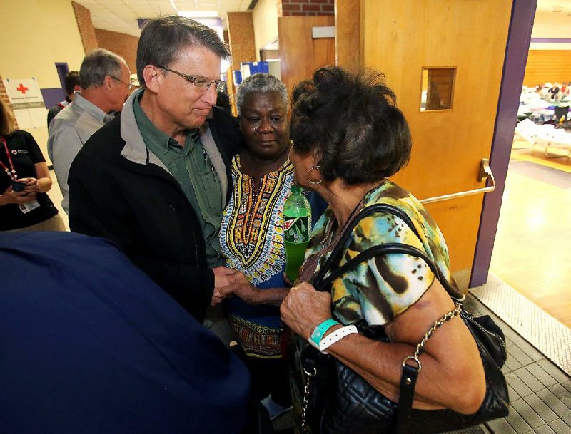 North Carolina Gov. Pat McCrory (from left) visits with Princeville residents Katherine Bullock and Betty Hinton on Friday at the American Red Cross shelter at Tarboro High School in Tarboro, N.C. Much of Princeville was flooded after heavy rainfall spawned by Hurricane Matthew. 
