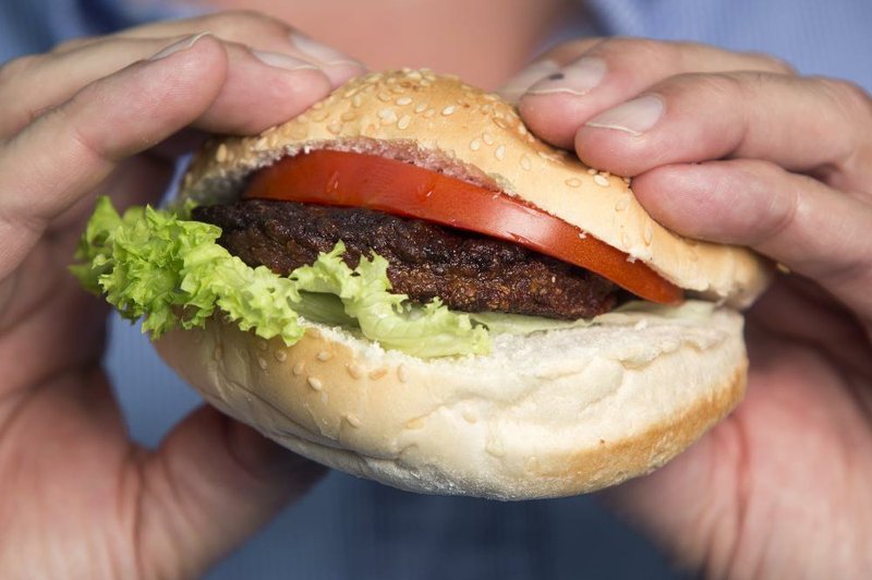 A beef burger created from stem cells harvested from a living cow is held by Dutch scientist Mark Post. 