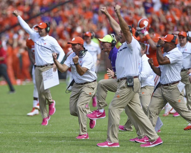 Coach Dabo Swinney (middle) and other Clemson coaches celebrate after North Carolina State missed a 33-yard field goal at the end of regulation Saturday. The No. 3 Tigers went on to beat the Wolfpack 24-17 in overtime.