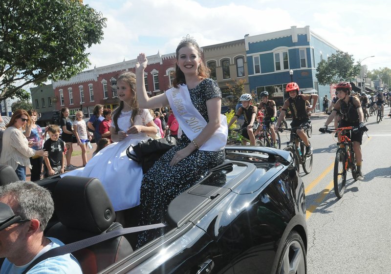 Katelyn Davis, Miss Bentonville High School, and her sister, Ariana Davis, 8, ride Saturday in the Bentonville homecoming parade in downtown.