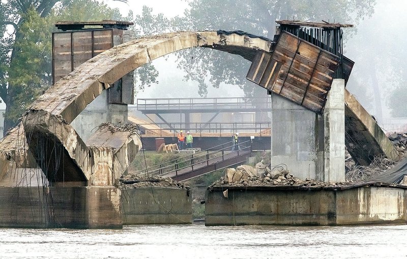 Arkansas Democrat-Gazette/JOHN SYKES JR. Explosives charges Satruday took down most of the concrete arches on the Broadway Bridge between Little Rock and North Little Rock. Workmen check out the one arch still standing after the detonation.