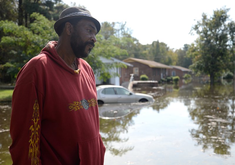 William Murrell stands at the edge of his property, which is partially underwater, on Cedar Lane in Kinston, N.C. , Friday, Oct. 14, 2016. Murrell and his wife Jo Ann weathered the storm following Hurricane Floyd in 1999 and chose to do this same during Hurricane Matthew. (Zach Frailey/Daily Free Press via AP)