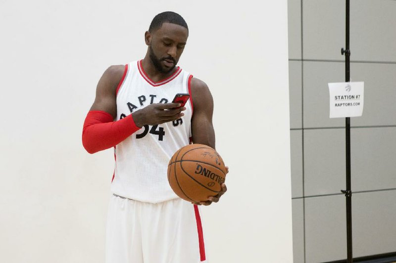 Toronto Raptors' Patrick Patterson takes a phote of a basketball at a media day for the NBA team in Toronto, Monday, Sept. 26, 2016. 