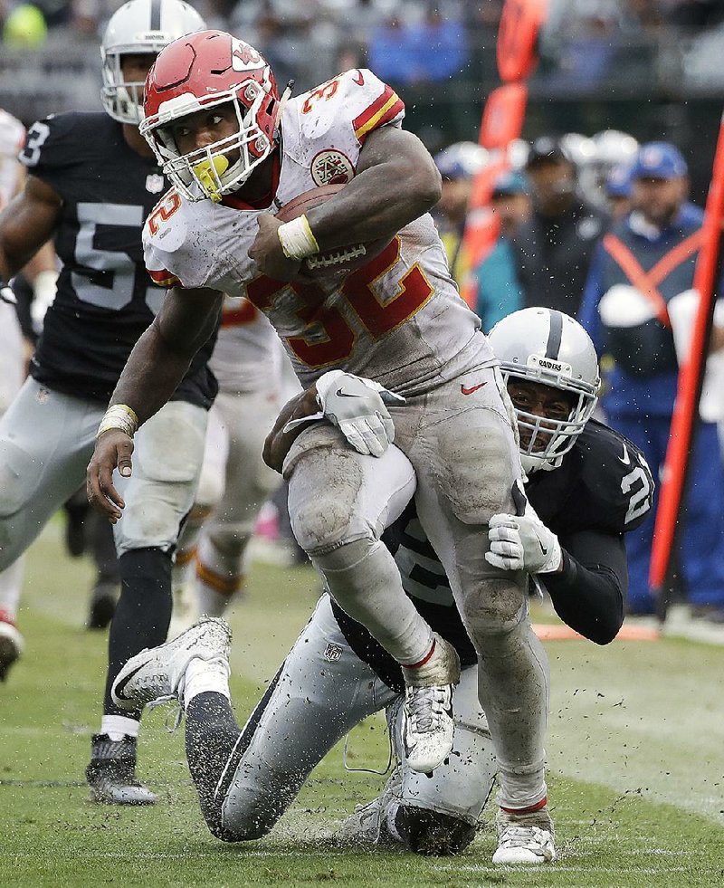 Kansas City Chiefs running back Spencer Ware (32) tries to break free from Oakland Raiders cornerback Sean Smith (21) during the second half Sunday in Oakland, Calif. Ware rushed for 131 yards and 1 touchdown on 24 carries.