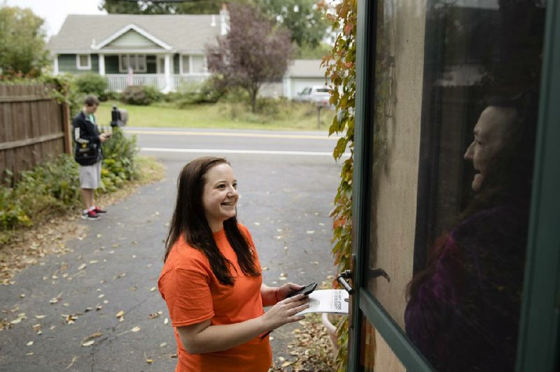 Kathryn Ferro with Americans for Prosperity speaks with a voter in Bensalem, Pa., recently. Workers campaigning for Republican Sen. Pat Toomey of Pennsylvania never mention presidential nominee Donald Trump.
