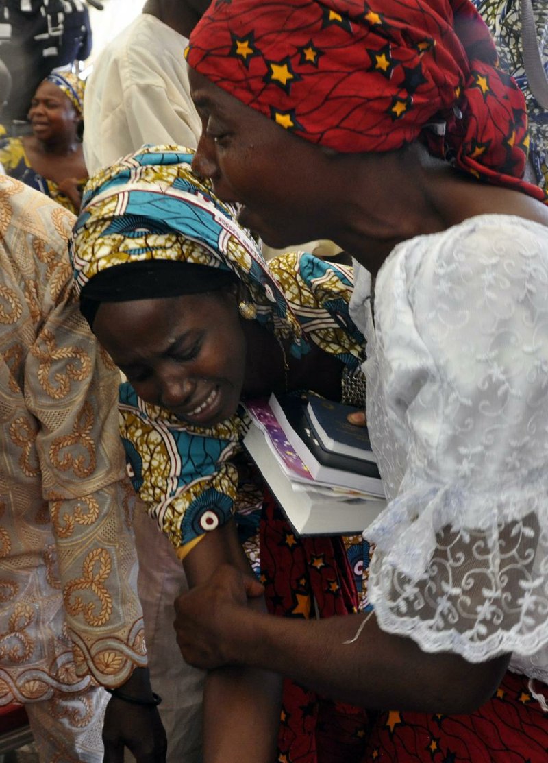 One of the girls released by kidnappers Thursday celebrates after being reunited with a family member during a church service Sunday in Abuja, Nigeria. The girls were among nearly 300 kidnapped in April 2014 from a Chibok school. Captors still hold 197.