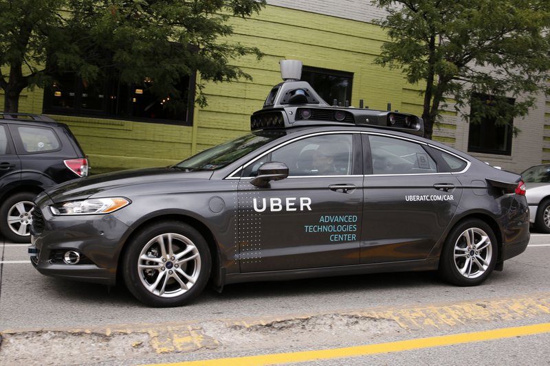 A self-driving Uber car drives through the Bloomfi eld neighborhood of Pittsburgh. The car is one of a fleet of Ford Fusions picking up riders who agreed to participate in a test program.