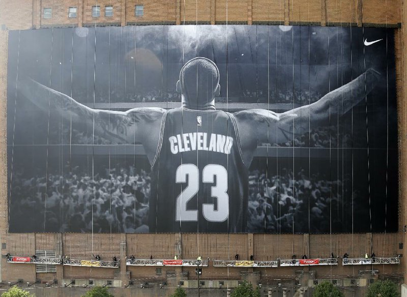 There will be an updated mural of Cleveland Cavaliers superstar LeBron James coming to downtown Cleveland
this week. The mural, which will occupy a 10-story space at Sherwin Williams headquarters across from
Quicken Loans Arena, includes a gold patch of the Larry O’Brien Trophy on the back of James’ uniform.