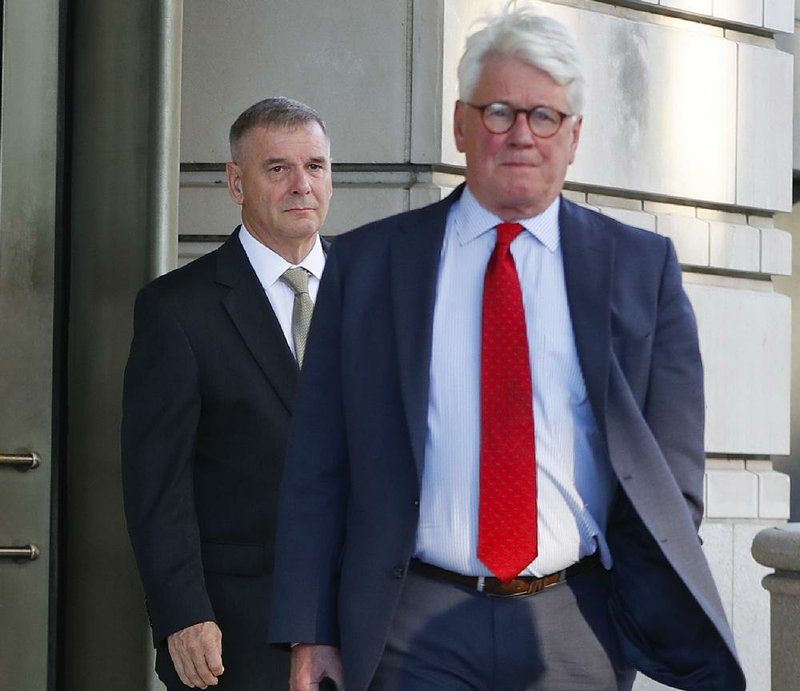 Retired Marine Gen. James Cartwright (left) and attorney Greg Craig leave U.S. District Court in Washington on Monday. Cartwright pleaded guilty to charges related to an investigation of leaked classified information about a cyberattack against Iran.
