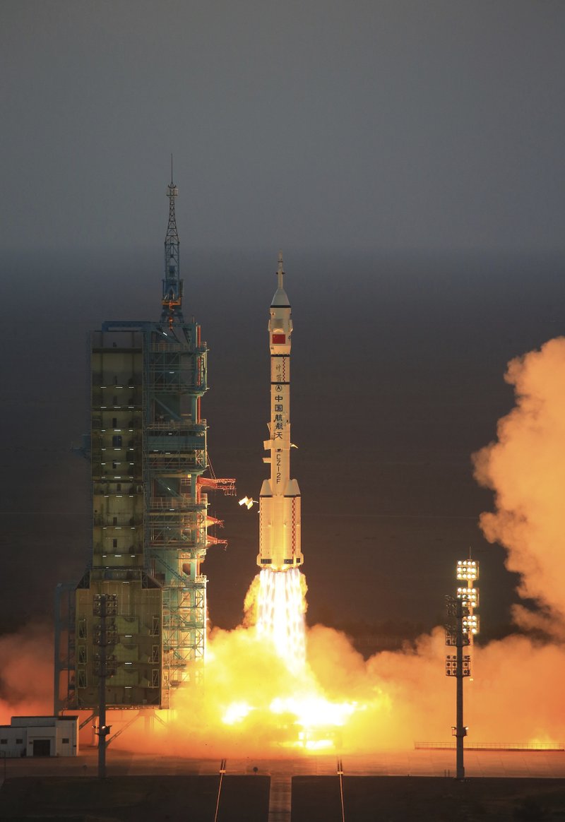 In this photo provided by China's Xinhua News Agency, the Long March-2F carrier rocket carrying China's Shenzhou 11 spacecraft blasts off from the launch pad at the Jiuquan Satellite Launch Center in Jiuquan, northwest China's Gansu Province, Monday, Oct. 17, 2016. China has launched a pair of astronauts into space on a mission to dock with an experimental space station and remain aboard for 30 days. (Li Gang/Xinhua via AP)