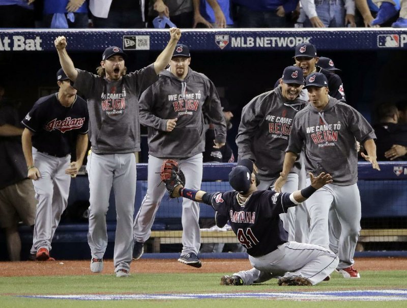 Cleveland players run on to the field after first baseman Carlos Santana (41) caught the final out as the Indians beat Toronto 3-0 on Wednesday to win their first American League Championship Series since 1997. Santana also had a home run in the game as Cleveland eliminated the Blue Jays in five games.