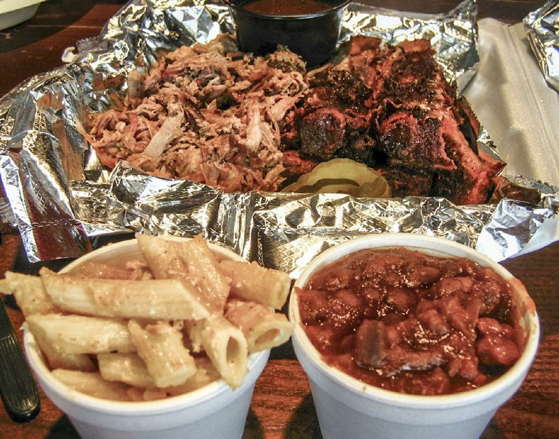 A portion of a Meat Sampler at CM Smoke Artisan BBQ, served here with macaroni and cheese and smoked barbecue beans, includes pulled pork, ribs and pickles. 