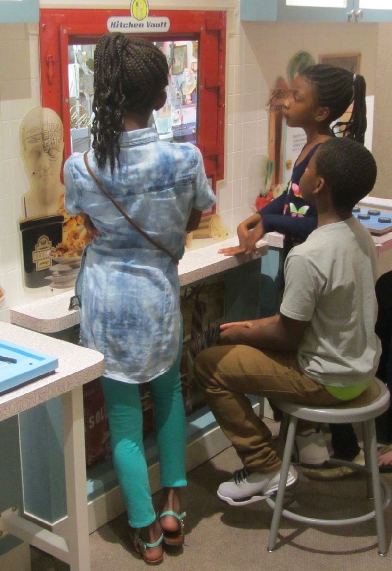 Young visitors to the Arkansas Museum of Natural Resources outside Smackover test their thinking skills in the Mindbender Mansion traveling exhibit. 