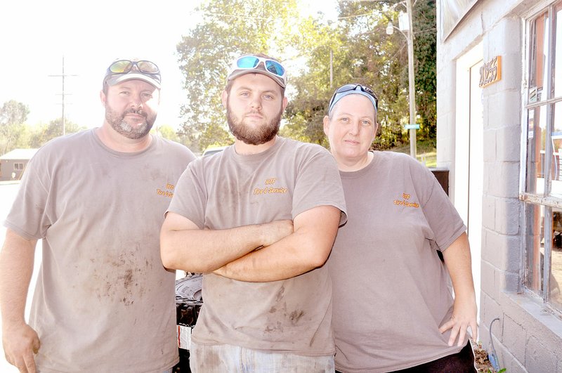 RACHEL DICKERSON/MCDONALD COUNTY PRESS Robert Faulkner, Trevyn Faulkner and Shanna Faulkner take a break from their work at RTF Tire and Service in Noel.