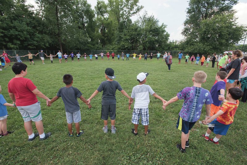 Shelley Duchesne (center, right) of Fayetteville has children form a circle while teaching some basic yoga moves during July’s summer camp at LifeSource International in Fayetteville. The Empty Bowls benefit Nov. 1 will help support the nonprofit organization.