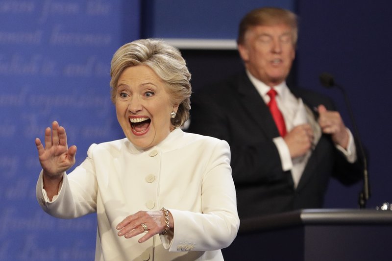 Democratic presidential nominee Hillary Clinton waves to the audience as Republican presidential nominee Donald Trump puts his notes away after the third presidential debate at UNLV in Las Vegas, Wednesday, Oct. 19, 2016. (AP Photo/John Locher)
