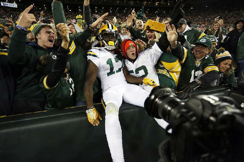 Green Bay wide receiver Davante Adams (middle) celebrates a touchdown with fans Thursday during the second half of the Packers’ 26-10 victory over the Chicago Bears at Lambeau Field in Green Bay, Wis. Adams fi nished with 13 catches for 132 yards and 2 touchdowns.
