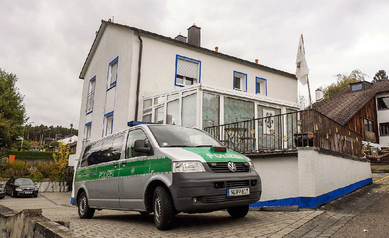 A police vehicle stands Wednesday in front of the house in Georgensgmuend, Germany, where an anti-government extremist opened fire on police during a raid.