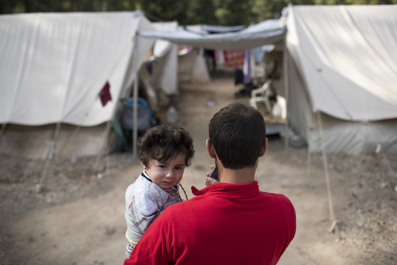 A Syrian man holds his eight month old daughter at Ritsona refugee camp north of Athens, on Wednesday, Oct. 19, 2016. About 600 people, mostly families with small children, live in tents in the camp, which officials say will soon be replaced by prefabricated homes. 