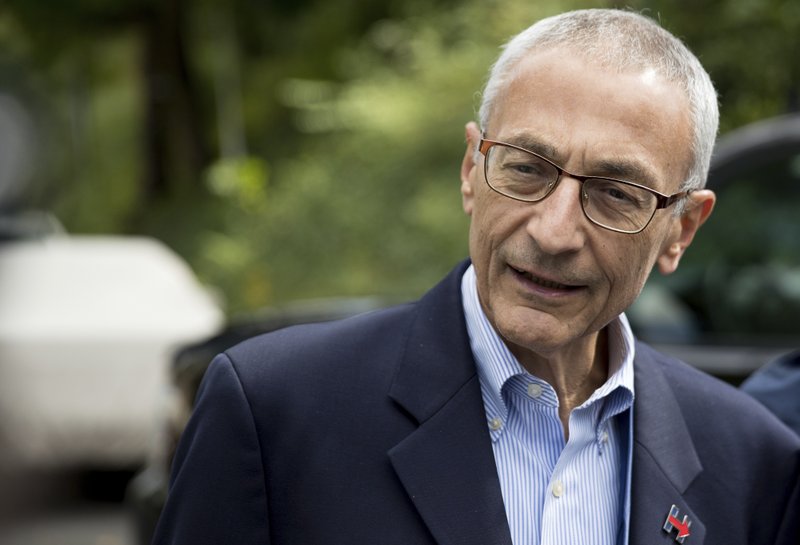 In this photo taken Oct. 5, 2016 file photo, Hillary Clinton's campaign manager John Podesta speaks to members of the media outside Democratic presidential candidate Hillary Clinton's home in Washington. 