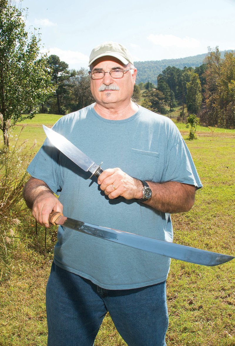 James Crowell, an American Bladesmith Society master smith, holds two blades from his collection. Crowell, who lives in Timbo outside of Mountain View, was inducted into the society’s Hall of Fame in August.