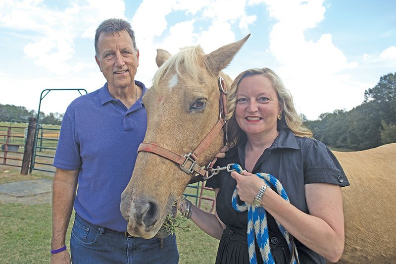 Jim Drake, Beyond Boundaries director of development, left, and Leslie Seward, director of events and marketing, stand with therapy horse Comanche at the Beyond Boundaries therapy center in Ward.