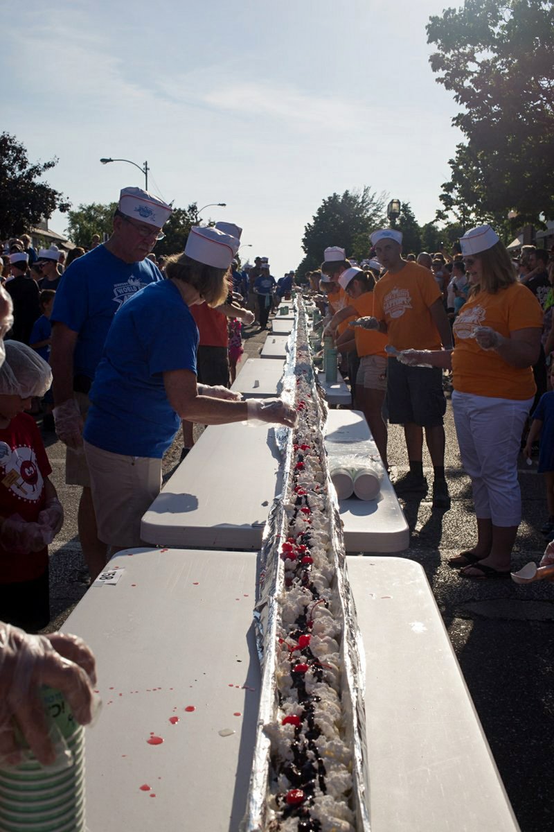In this June 11, 2016 file photo, an ice cream sundae is completed during the world record attempt for the longest ice cream dessert along eight city blocks in Ludington, Mich. House of Flavors, one of Michigan's original, continuously-operating ice cream makers and parlors put on the event. 