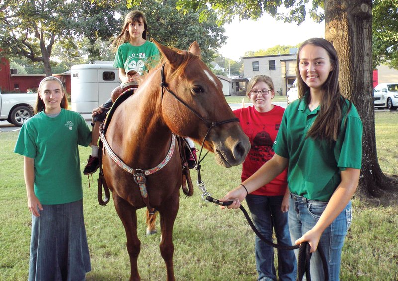 Members of the Lollie Bottoms 4-H Riders offered rides on a horse during the 4-H Party on the Lawn at the Faulkner County Courthouse. Sierra Puckett, front, a member of the Lollie Bottoms 4-H Riders, leads the horse for the rider, Sarah Lynn Blount, a member of the Green Garden Project 4-H Club. Assisting with the ride are Grace Brodsky, left, also a member of the Lollie Bottoms 4-H Riders, and Ashley Moore, a member of the Faulkner County Hooves, Spurs and Furs Show Team.