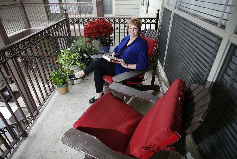 Angie Albright sits Thursday, October 13, 2016, in her favorite personal space, the front balcony of her condominium in Fayetteville.